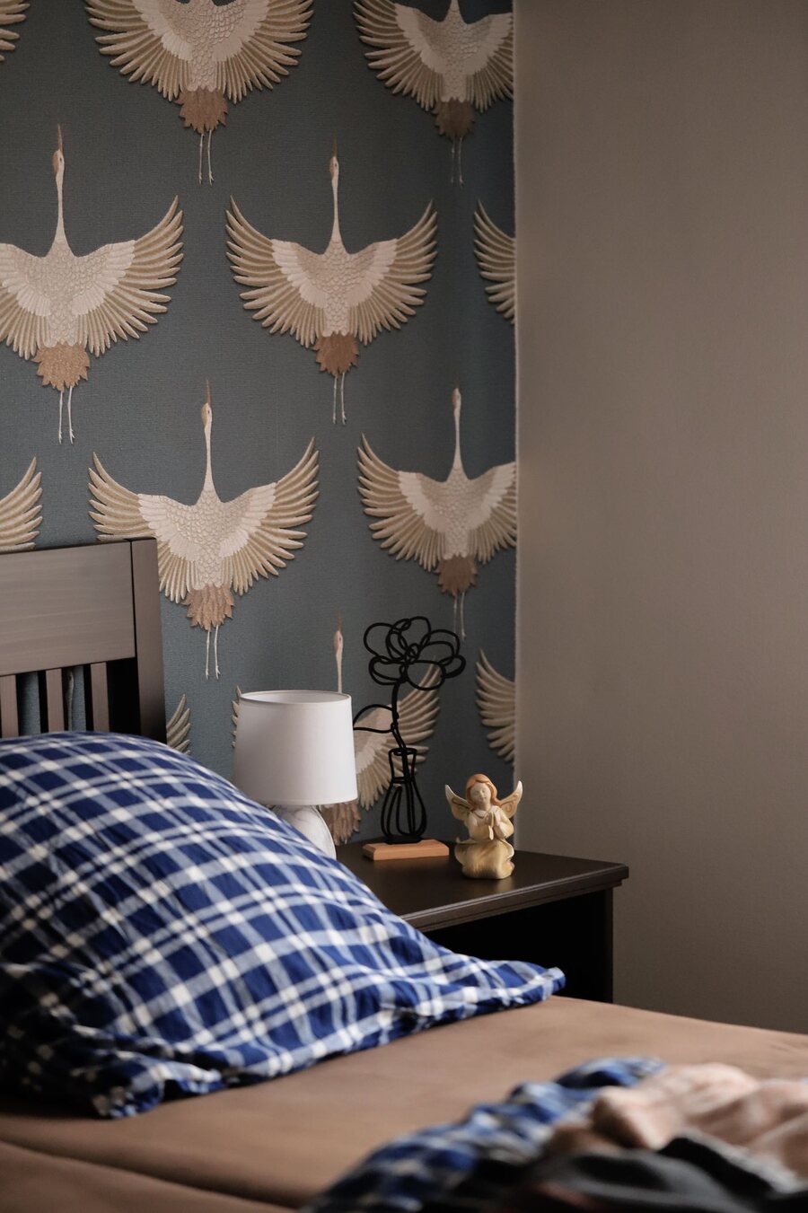 Bedroom feature wall in a soft blue crane-motif wallpaper