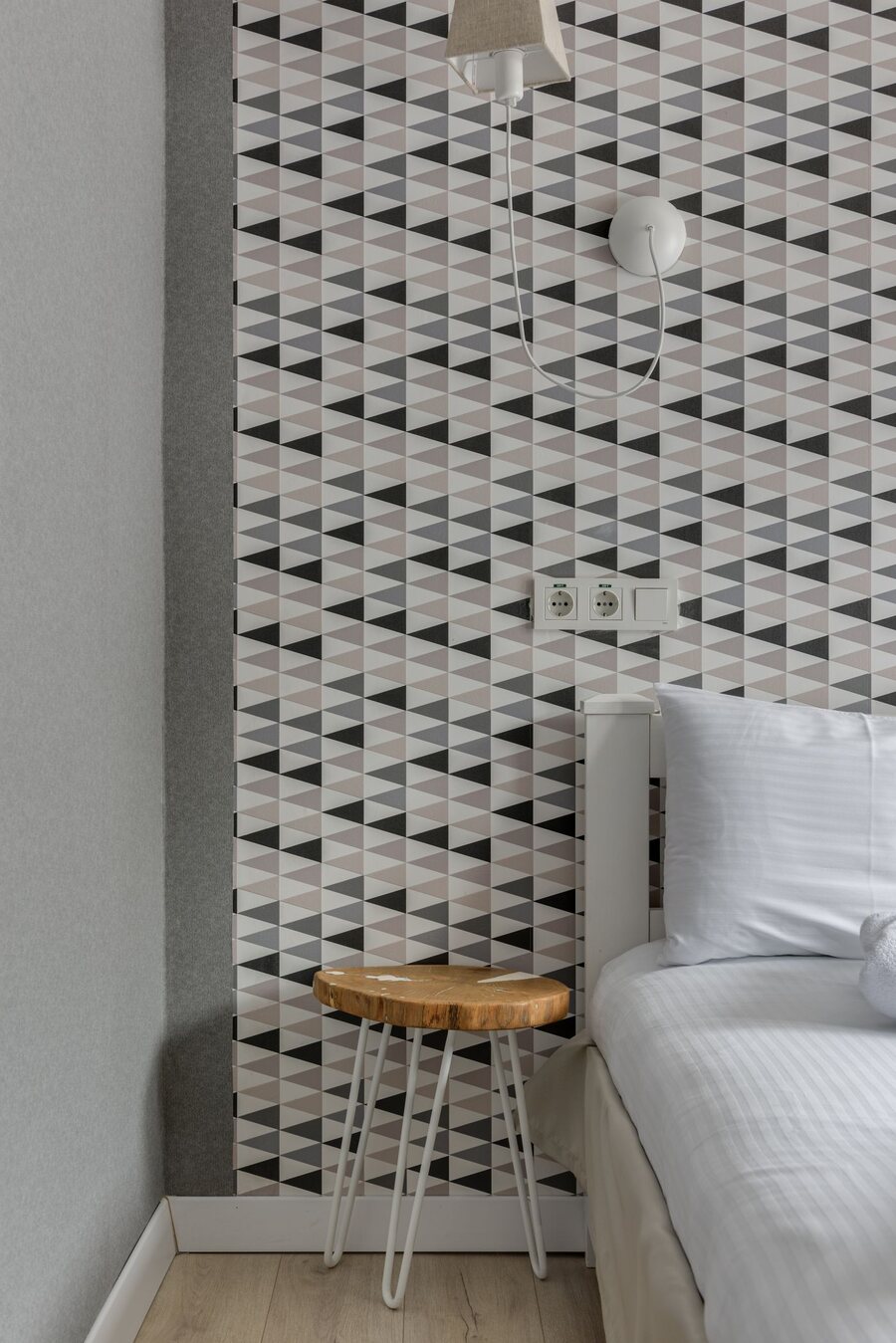Modern bedroom corner with a crisp black-and-white geometric wallpaper