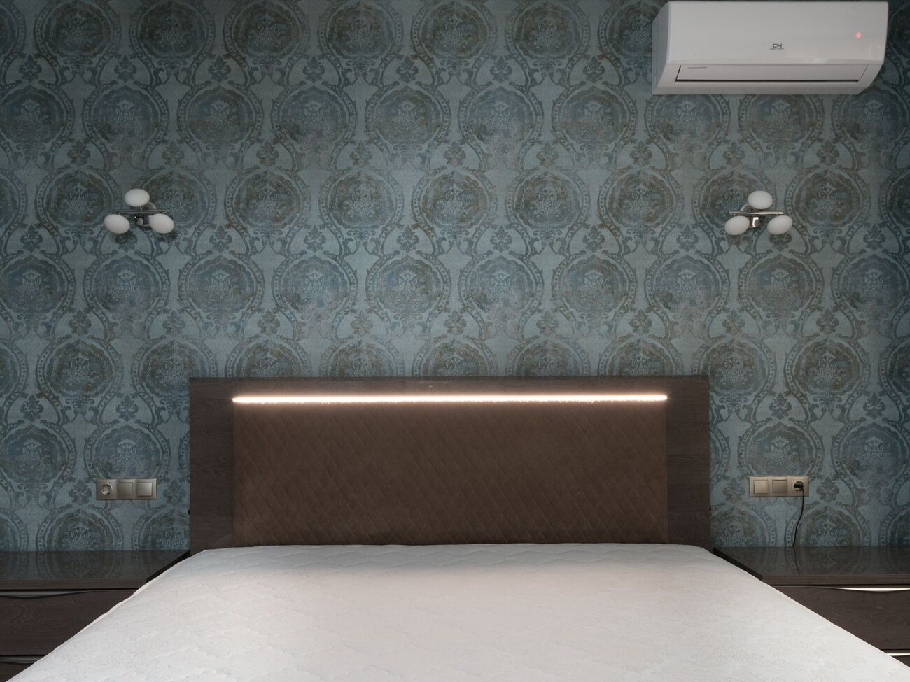 Dramatic teal damask feature wall behind an upholstered bed with soft lighting